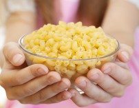 Little girl holding bowl with pasta Little girl holding bowl with pasta